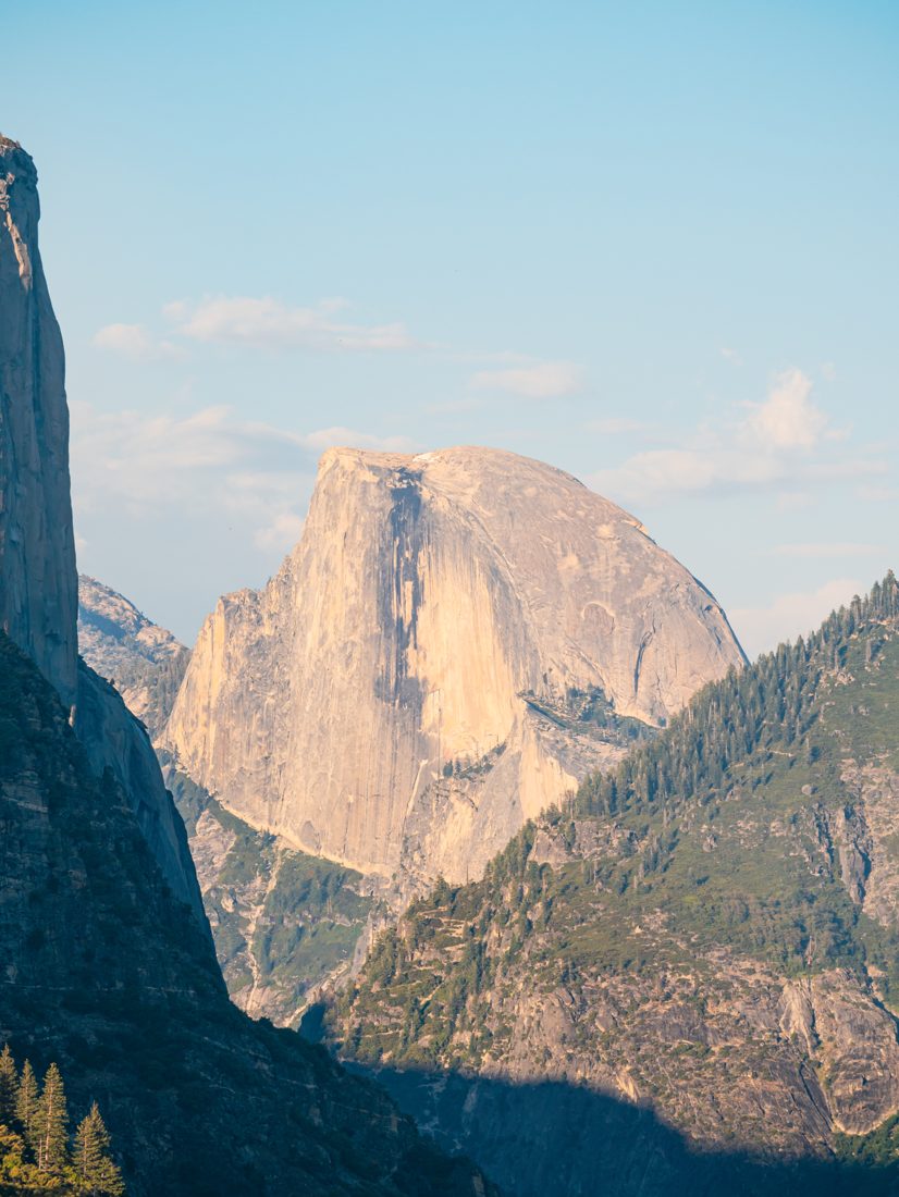 Half Dome at golden hour with a dark cliff framing the left edge